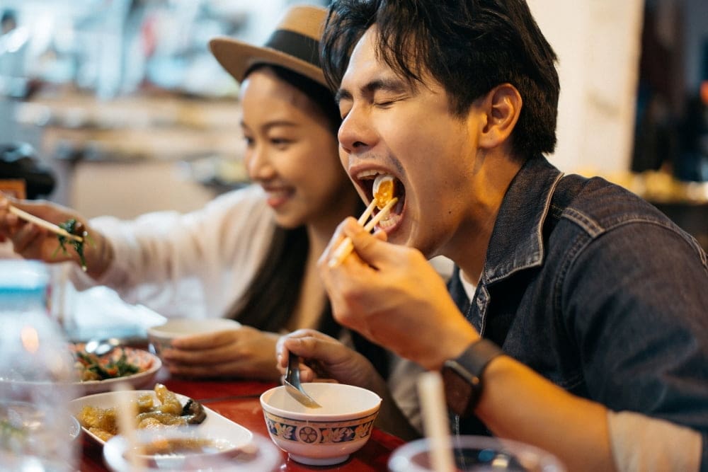 A couple enjoying food at a night market in Bangkok