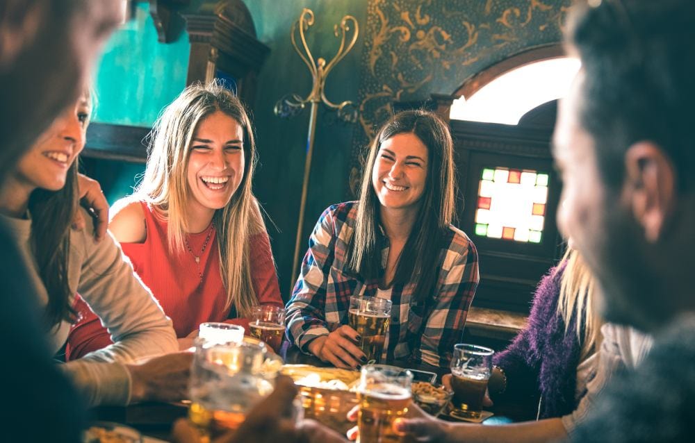 a group of friends enjoy drinks and conversation while at a speakeasy bar