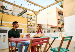 two people enjoy a light meal on an open-air rooftop